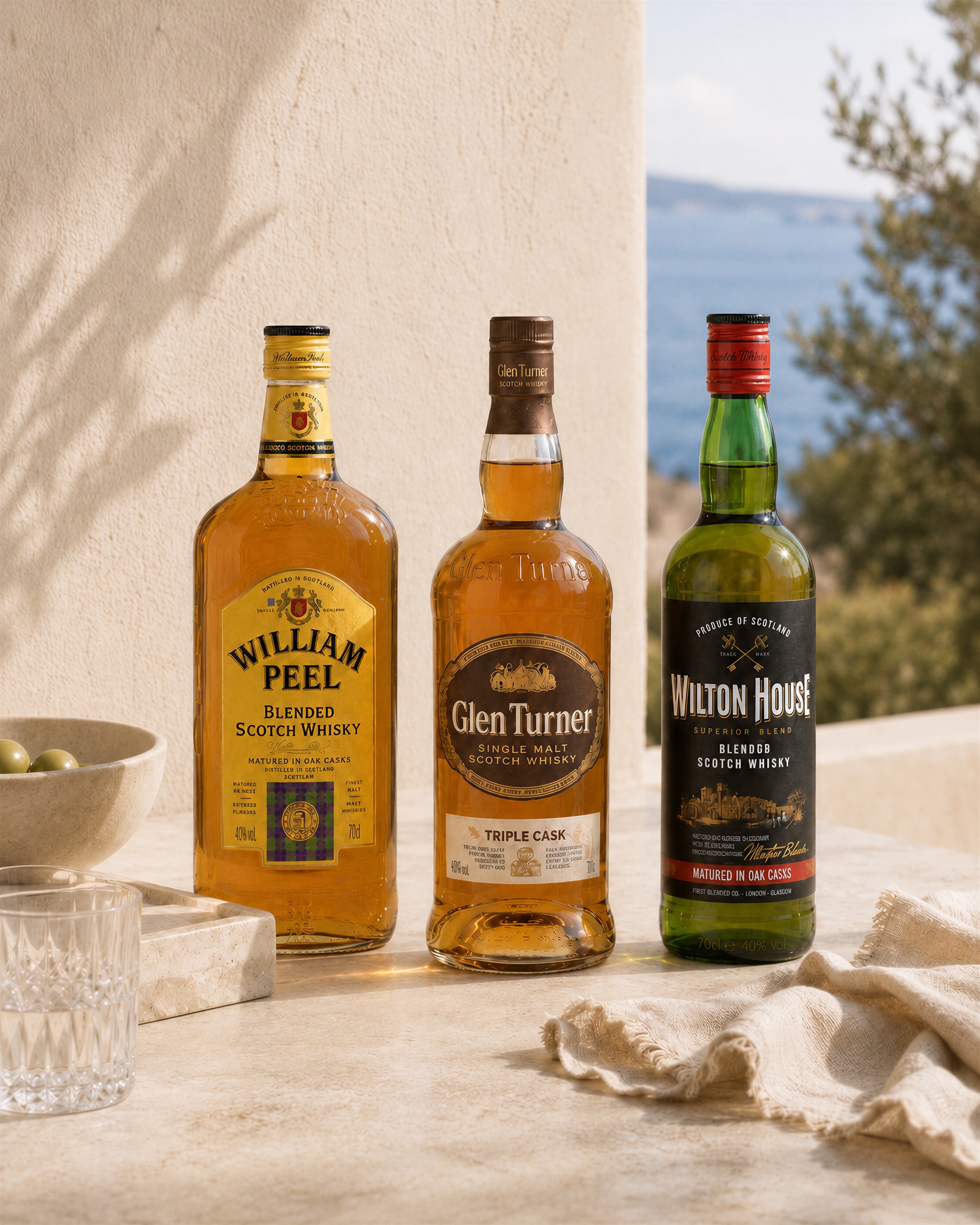 Single malt Glen Turner junto a los blended scotch William Peel y Wilton House, con vasos de whisky sobre piedra